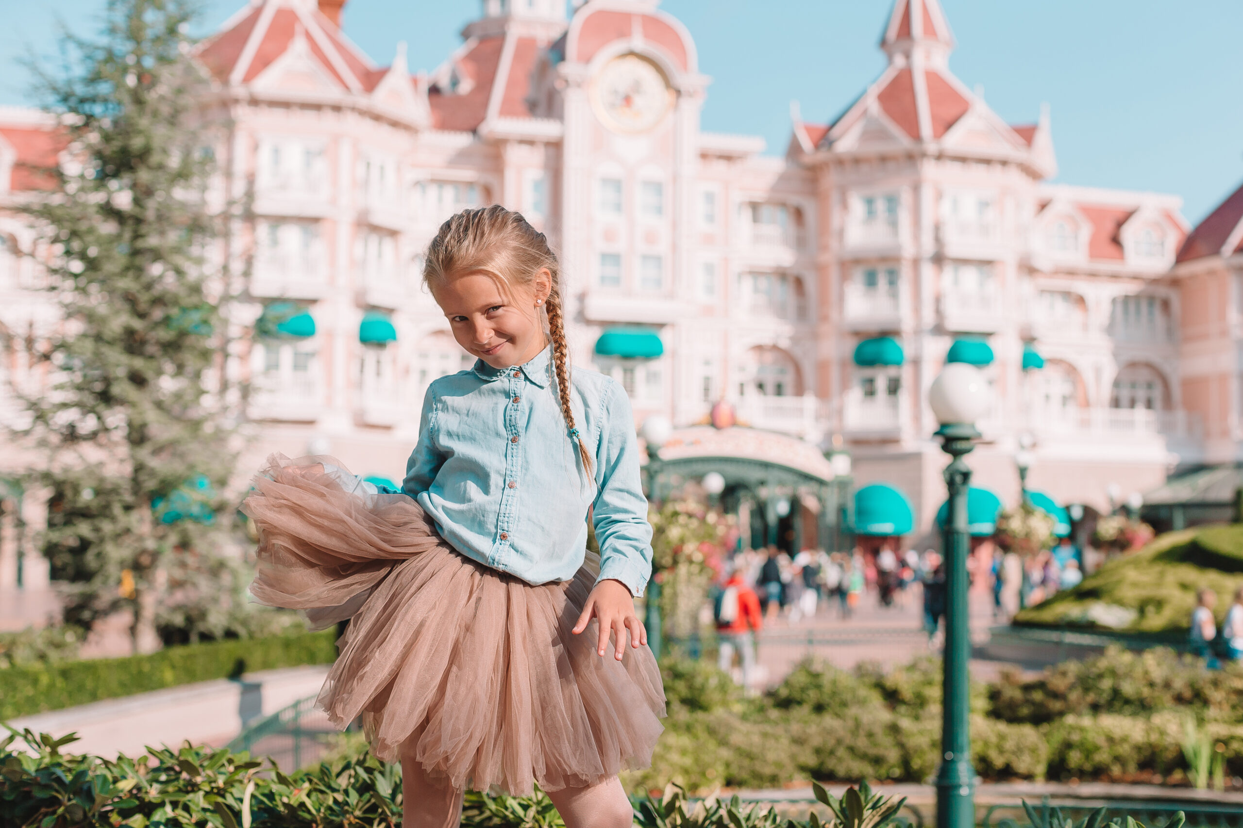 girl standing in front of the Disneyland Hotel at Disneyland Paris