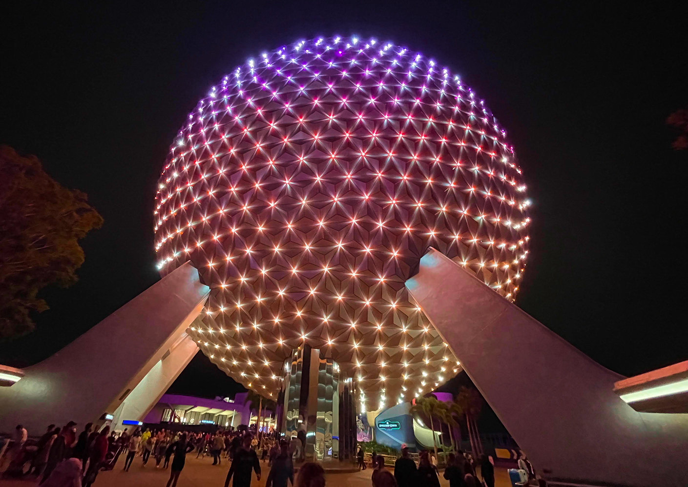 Spaceship Earth illuminated in purple and warm light at EPCOT after dark
