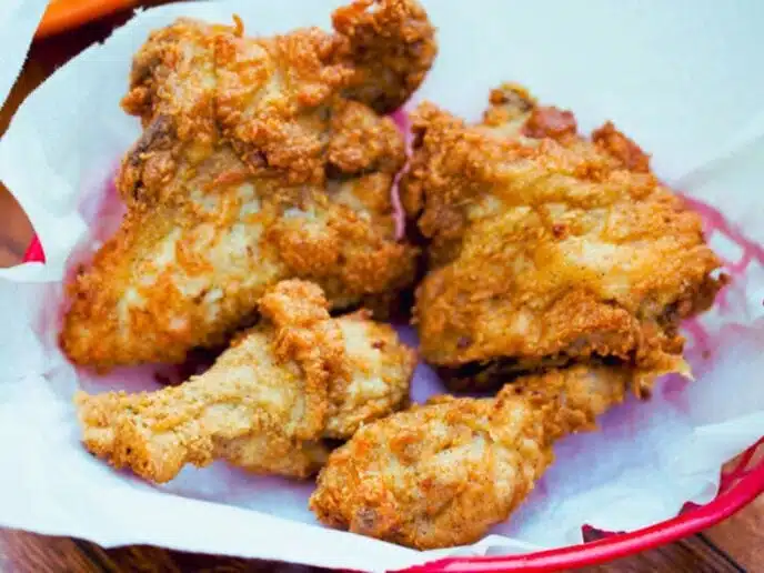 cooked chicken pieces in paper lined basket.