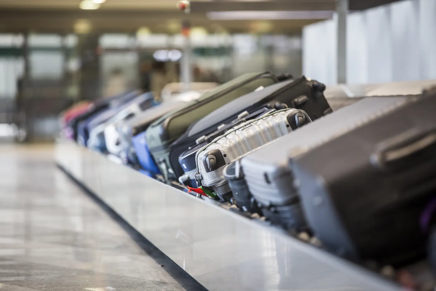 Several suitcases traveling along an airport baggage carousel.