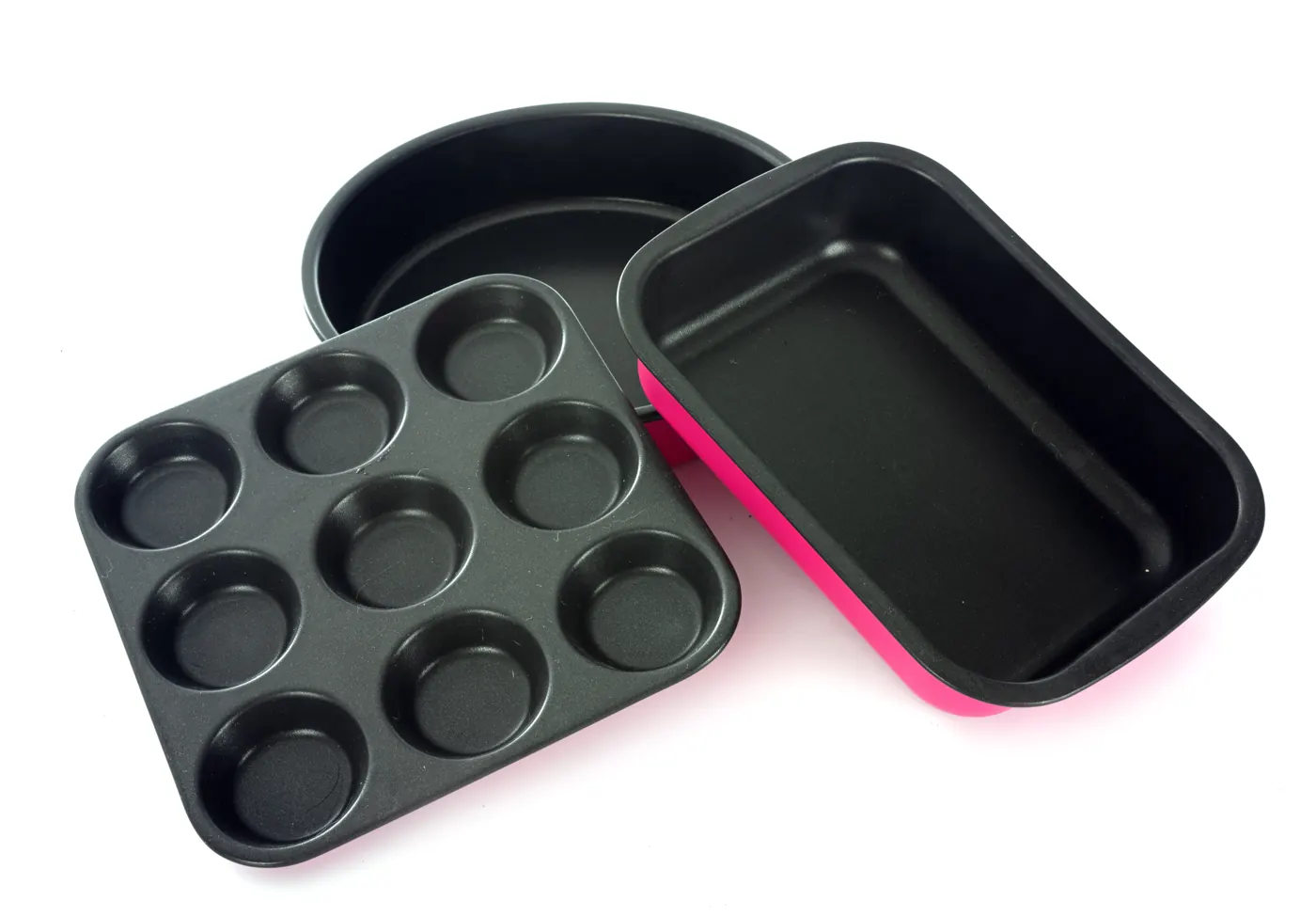 Dark round, rectangular, and muffin baking tins arranged on white