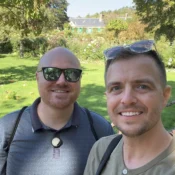 Beau and Sean smiling in Monet’s flower garden, with the house behind them.