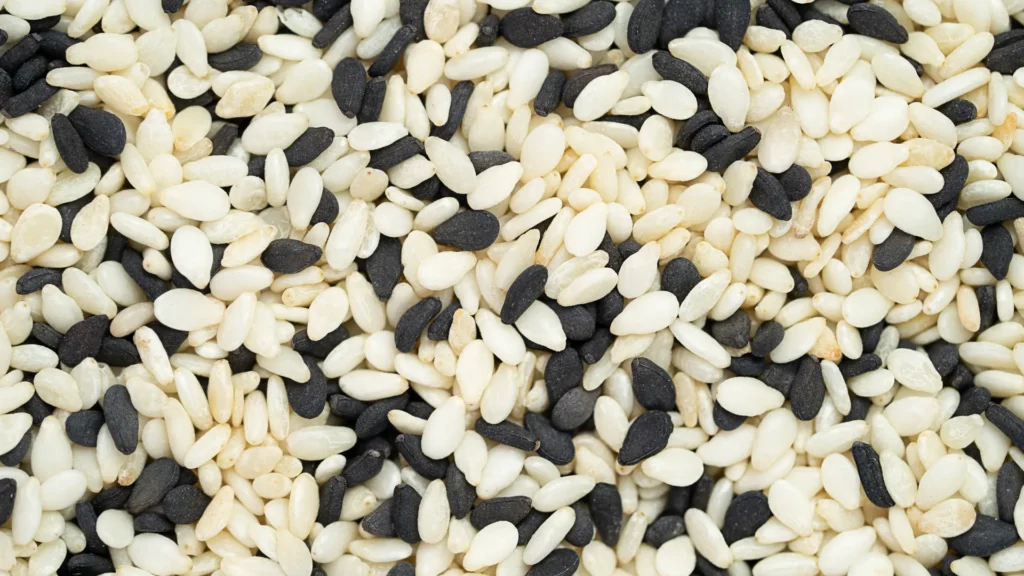 A close view of black and pale sesame seeds mixed together.