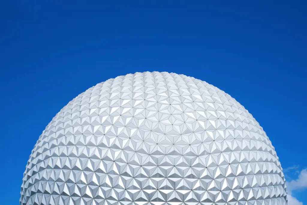 Spaceship Earth at EPCOT shining in the sun beneath a clear blue sky
