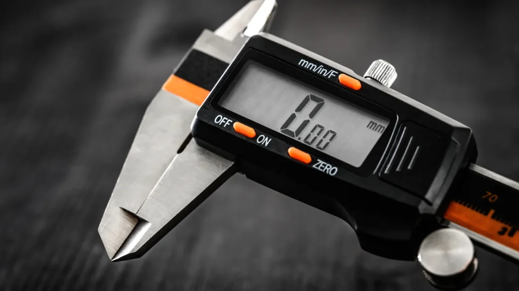Close-up of a digital caliper with closed measuring jaws and a zero reading