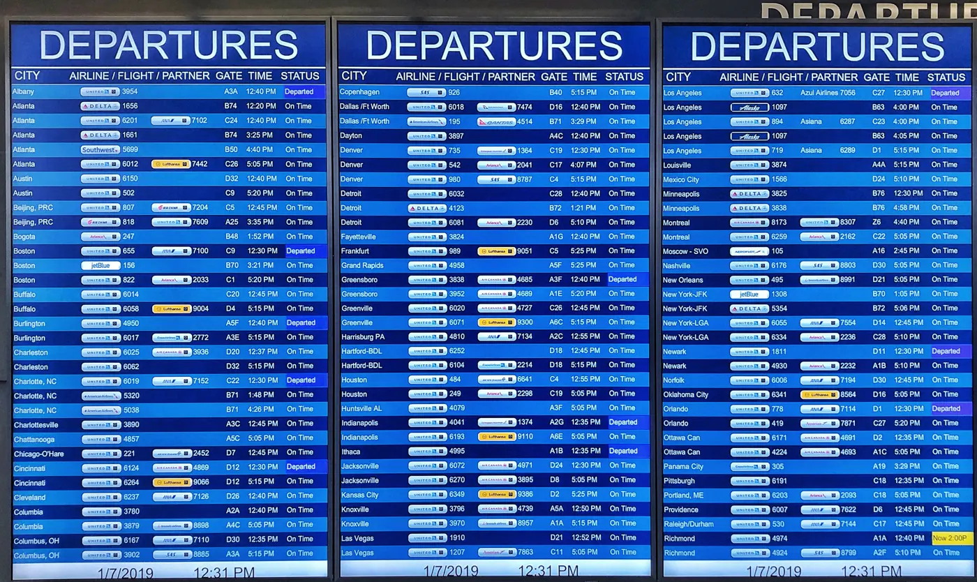 Three blue airport departures screens list destinations, flight numbers, gates, and times.