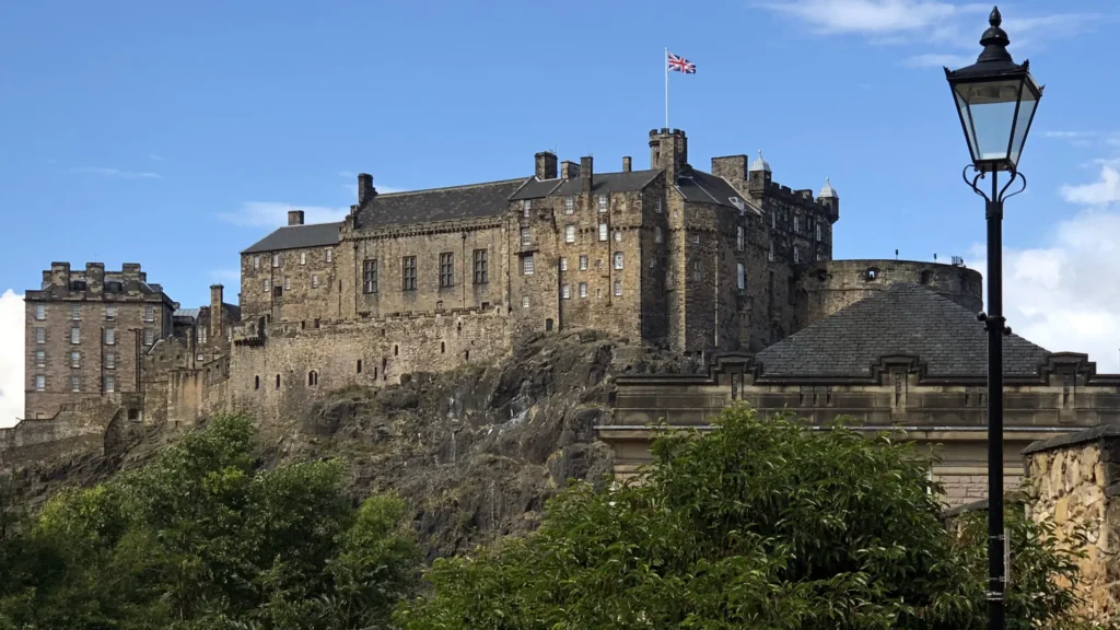 Edinburgh Castle stone buildings rising above the rocky hillside