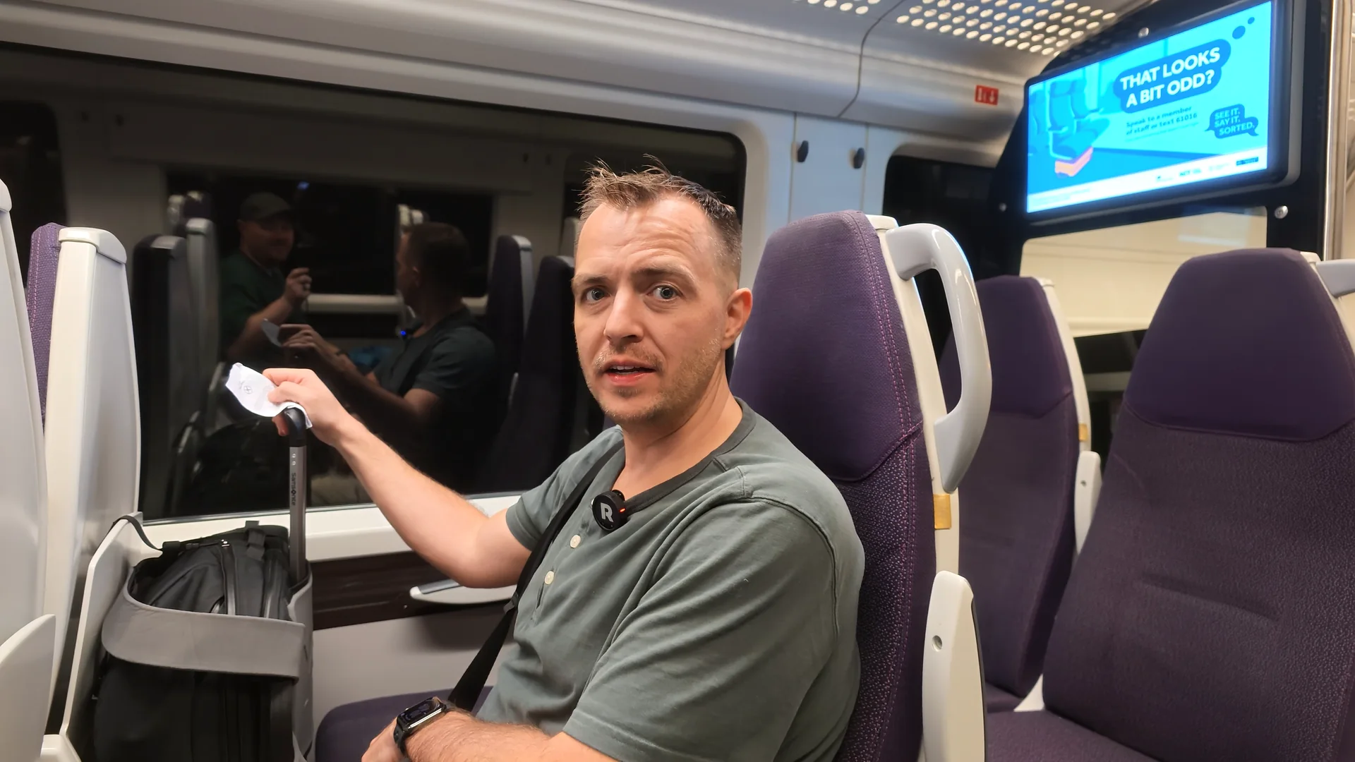 Beau aboard the Heathrow Express with luggage beside his seat.
