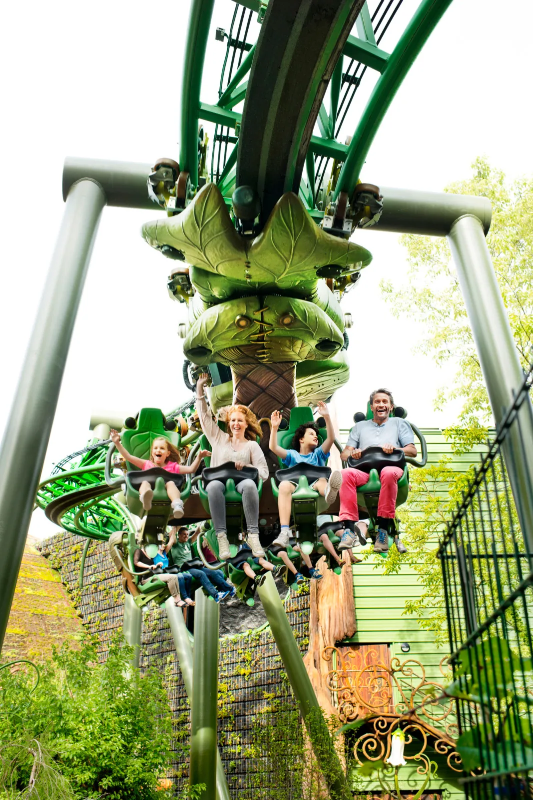 Riders suspended beneath green track on the ARTHUR attraction.