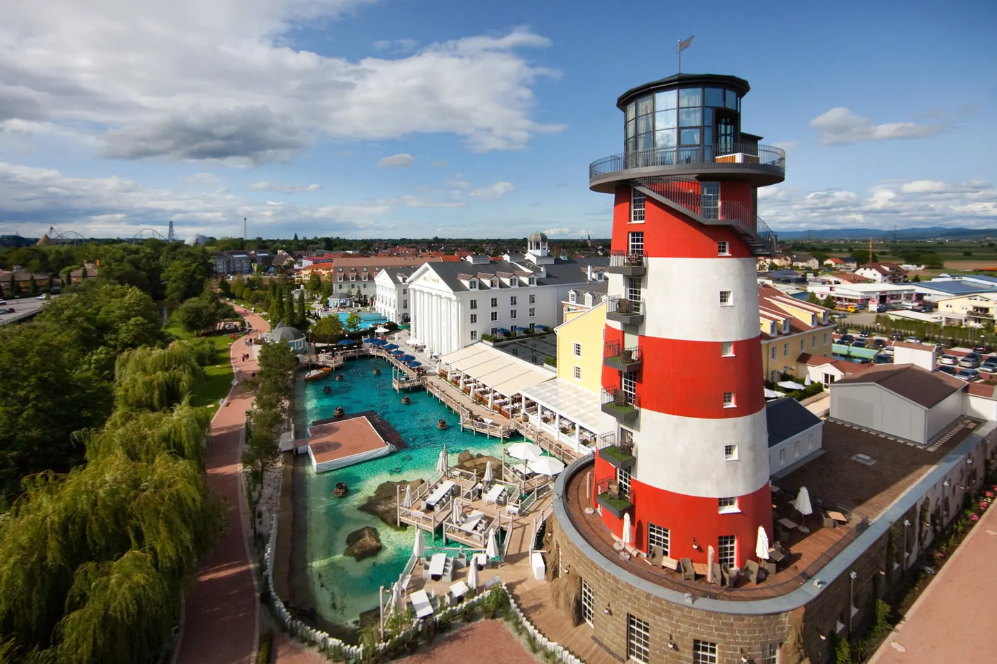Hotel Bell Rock’s red-and-white lighthouse beside the water and hotel buildings.