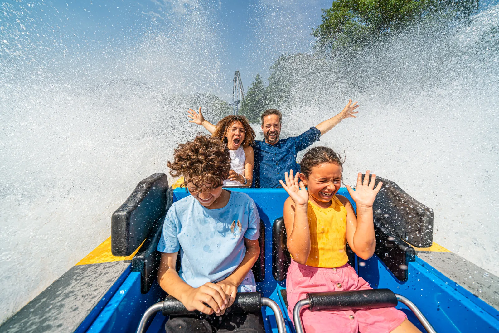 A family riding through a splash on the Poseidon water coaster.