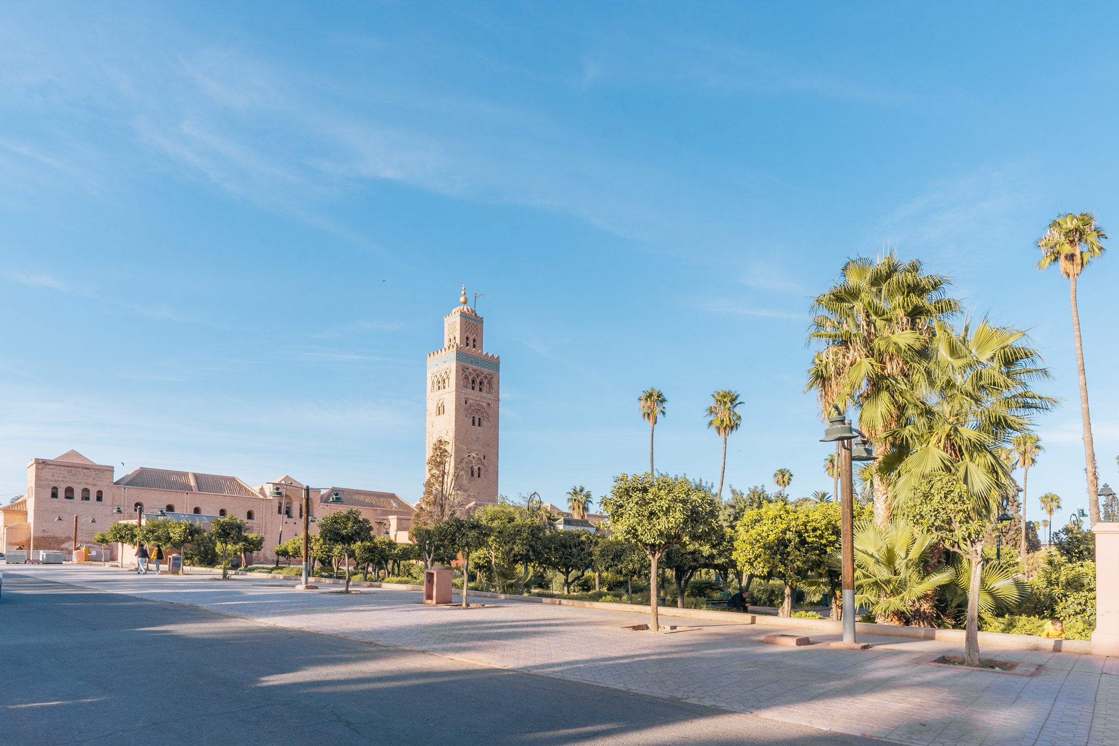 The square minaret of Koutoubia Mosque rises above palm trees in Marrakech