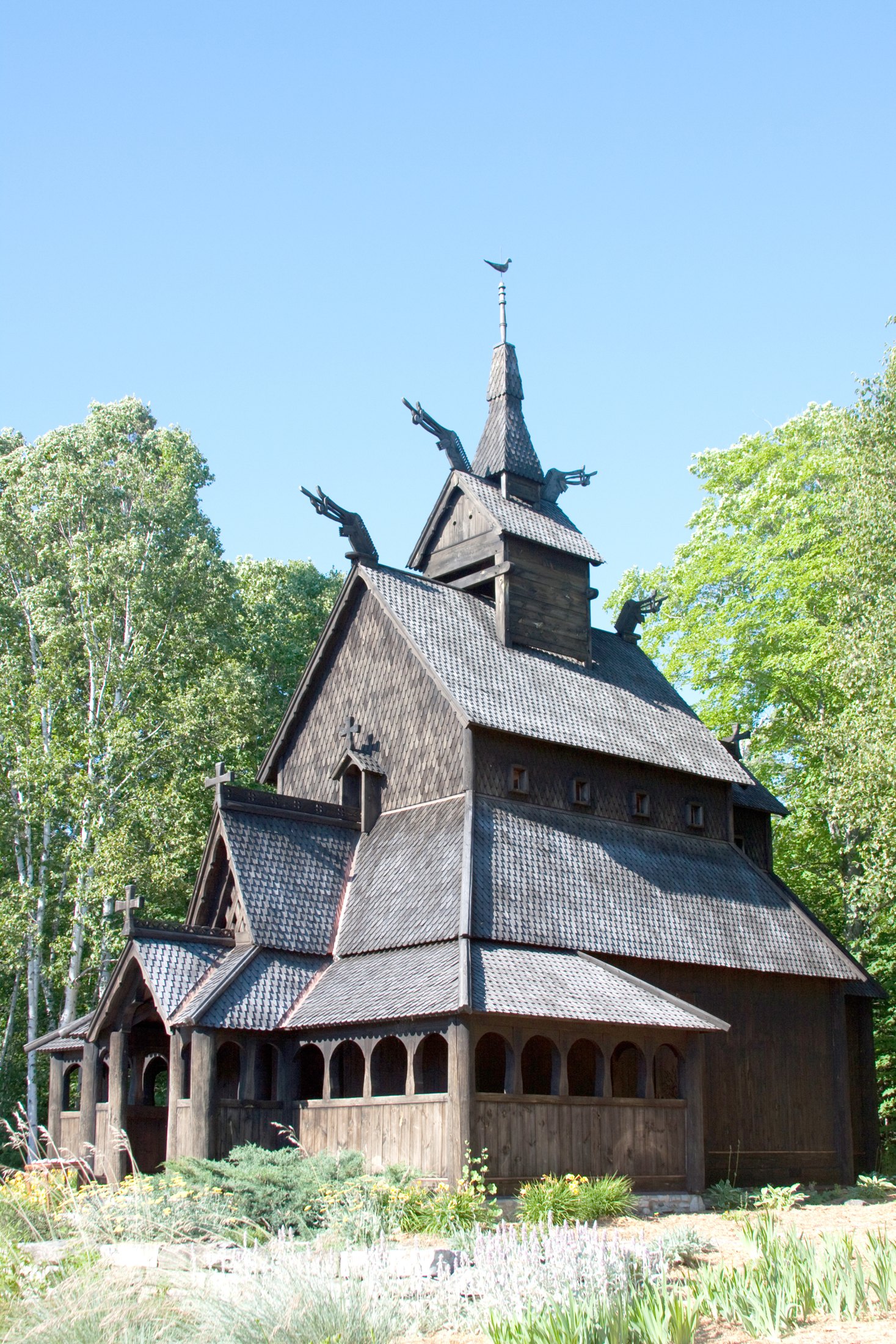 Gol Stave Church’s dark timber walls and layered shingled roofs among trees in Oslo