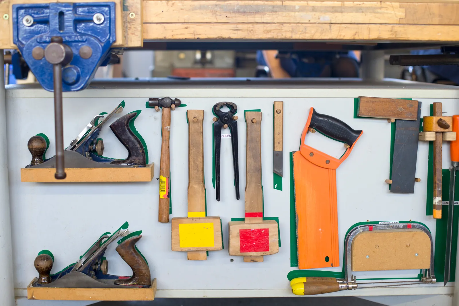 Hand tools neatly arranged on a workshop wall.