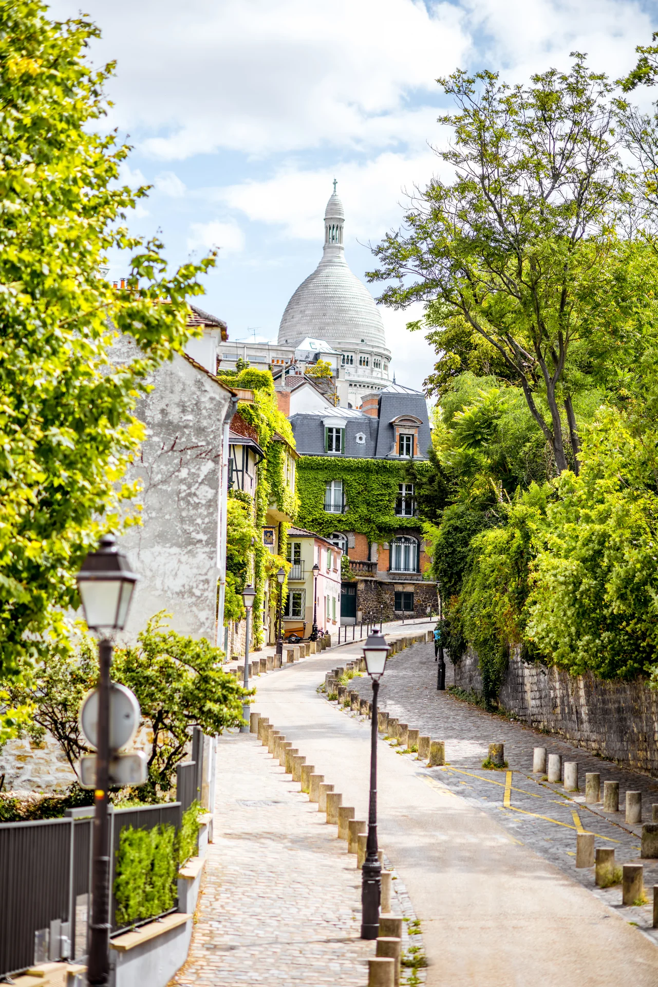 A Montmartre street climbs toward the white domes of Sacré-Cœur