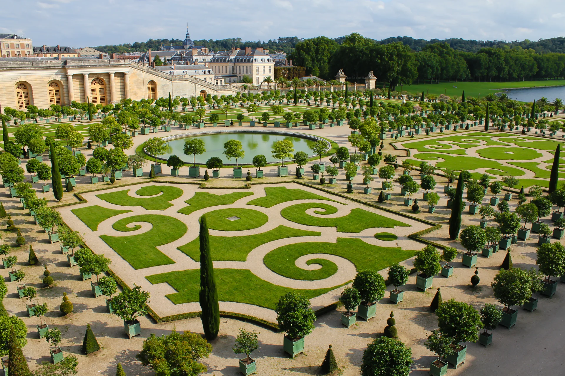 Patterned parterres and clipped trees show the scale of Versailles’s formal gardens