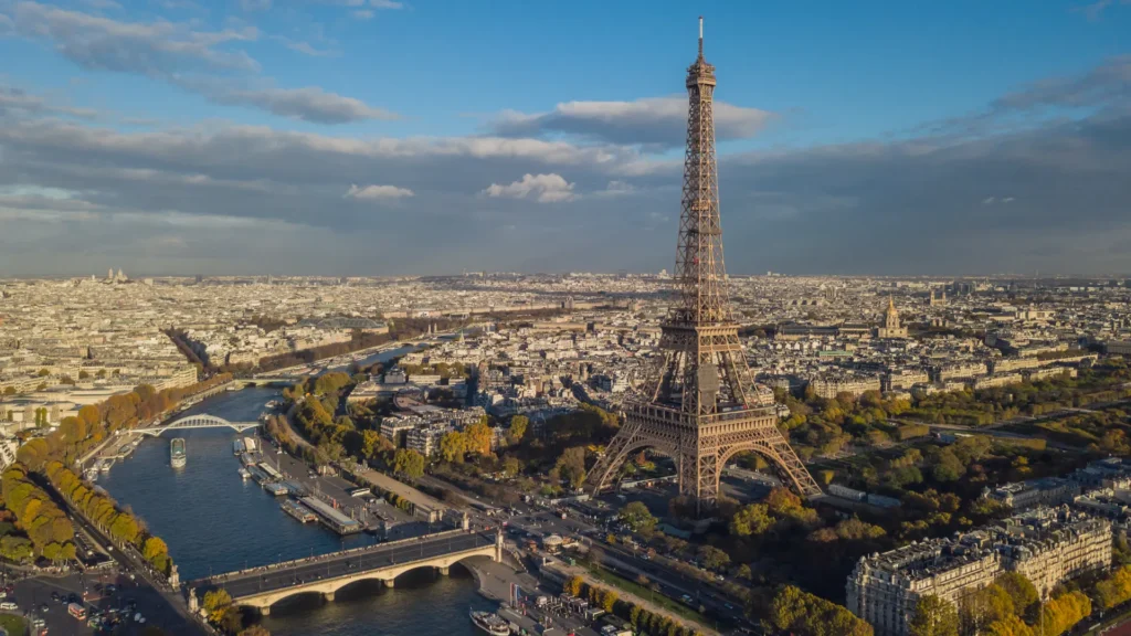 Elevated view across Paris rooftops, the Seine, and the Eiffel Tower.