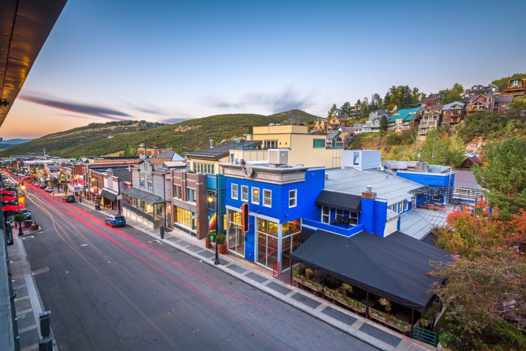 Park City’s Main Street at twilight, with colorful buildings and hills beyond.