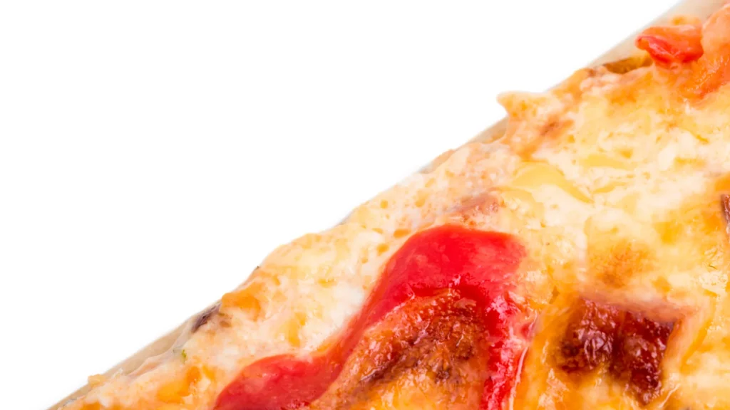 A close-up of a pizza slice with melted cheese and tomato topping.