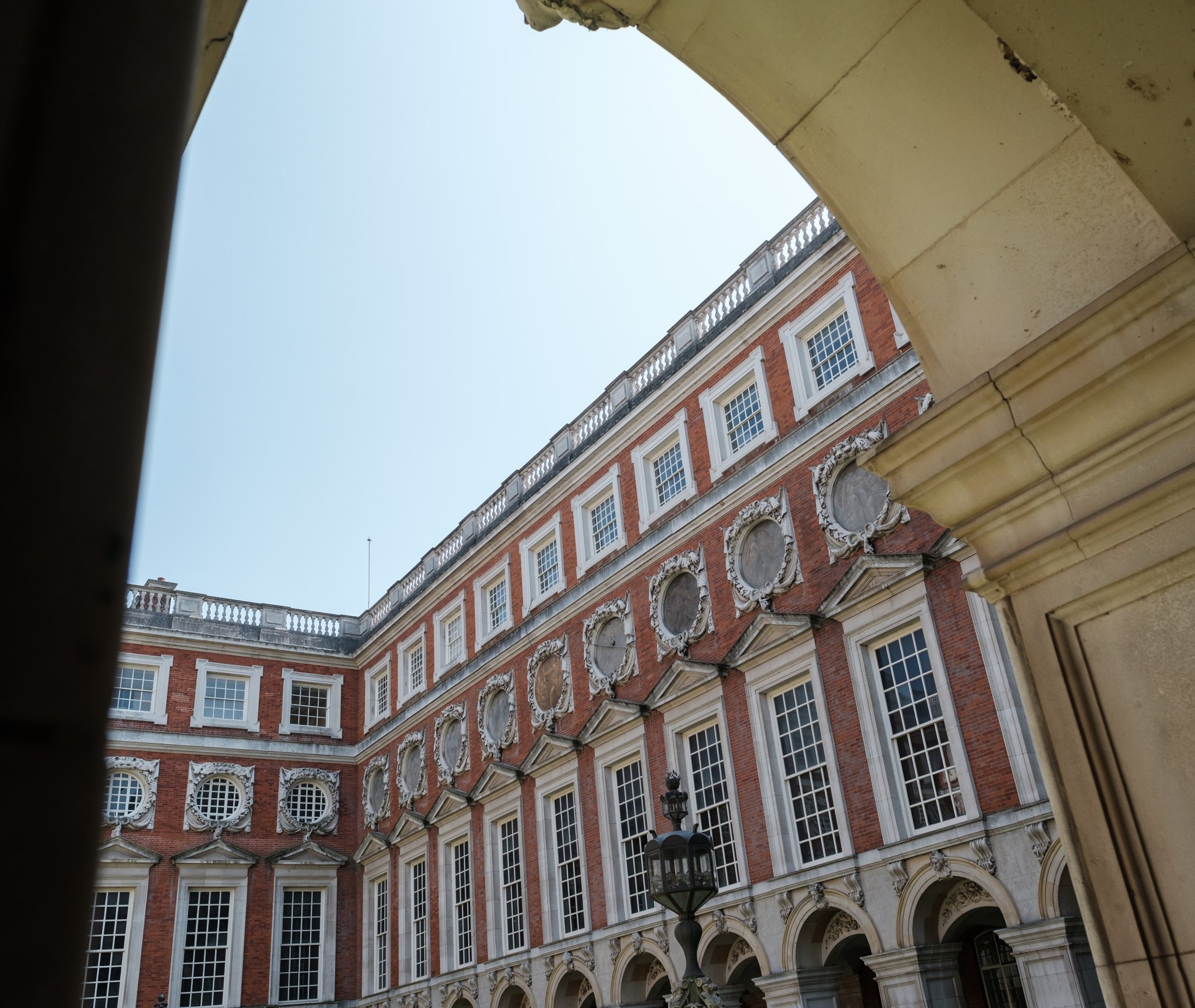 Hampton Court Palace’s brick and stone Fountain Court framed by an archway