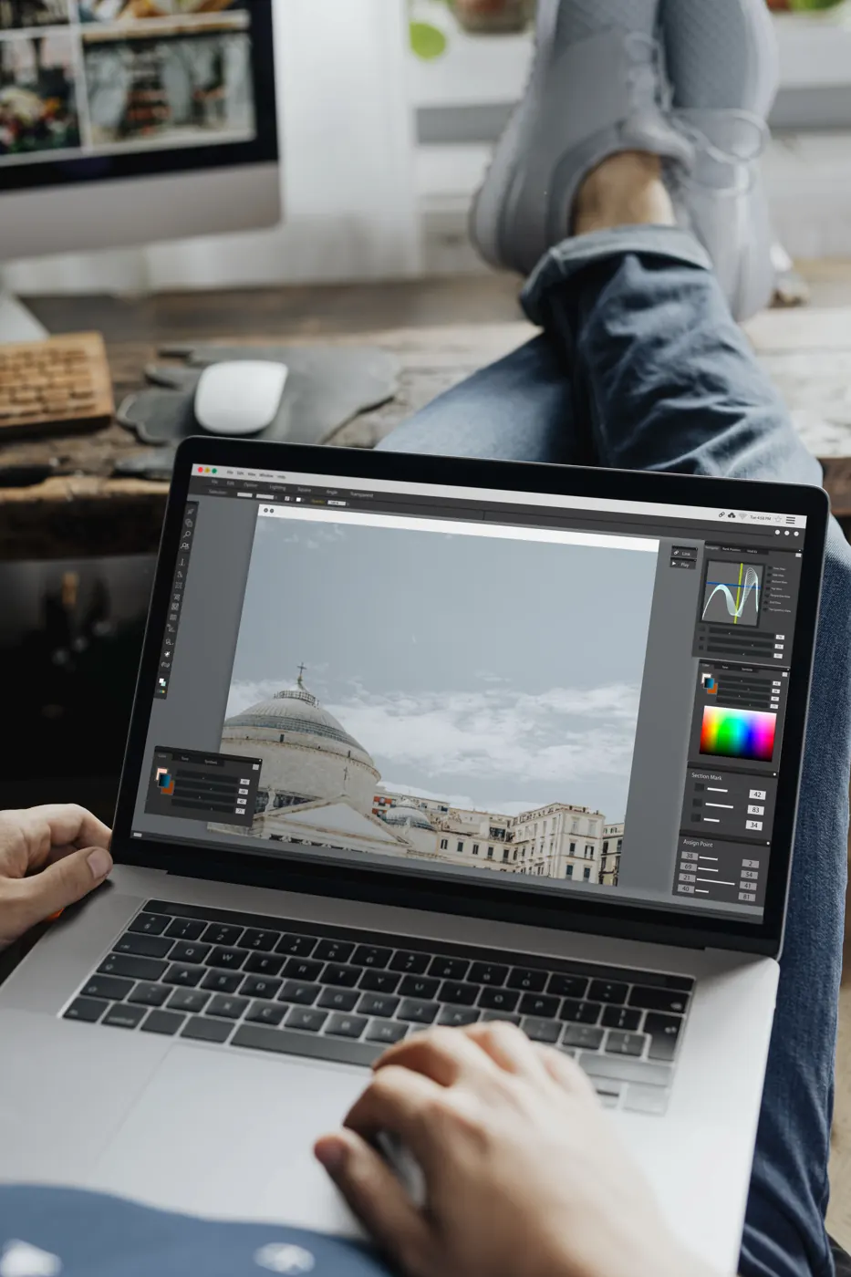 Hands using a laptop to edit an architectural photograph.